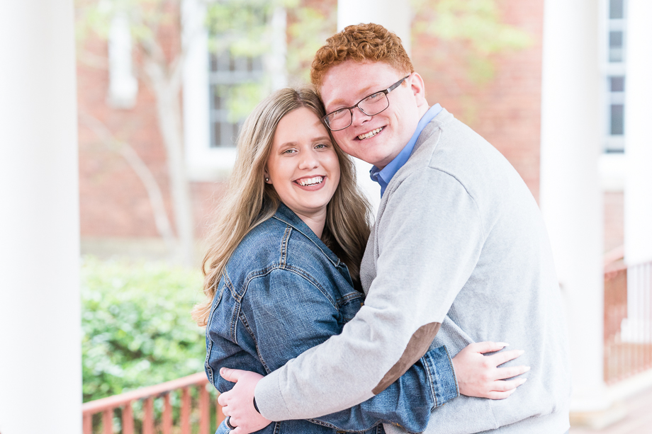 engaged couple hugging on college campus portrait